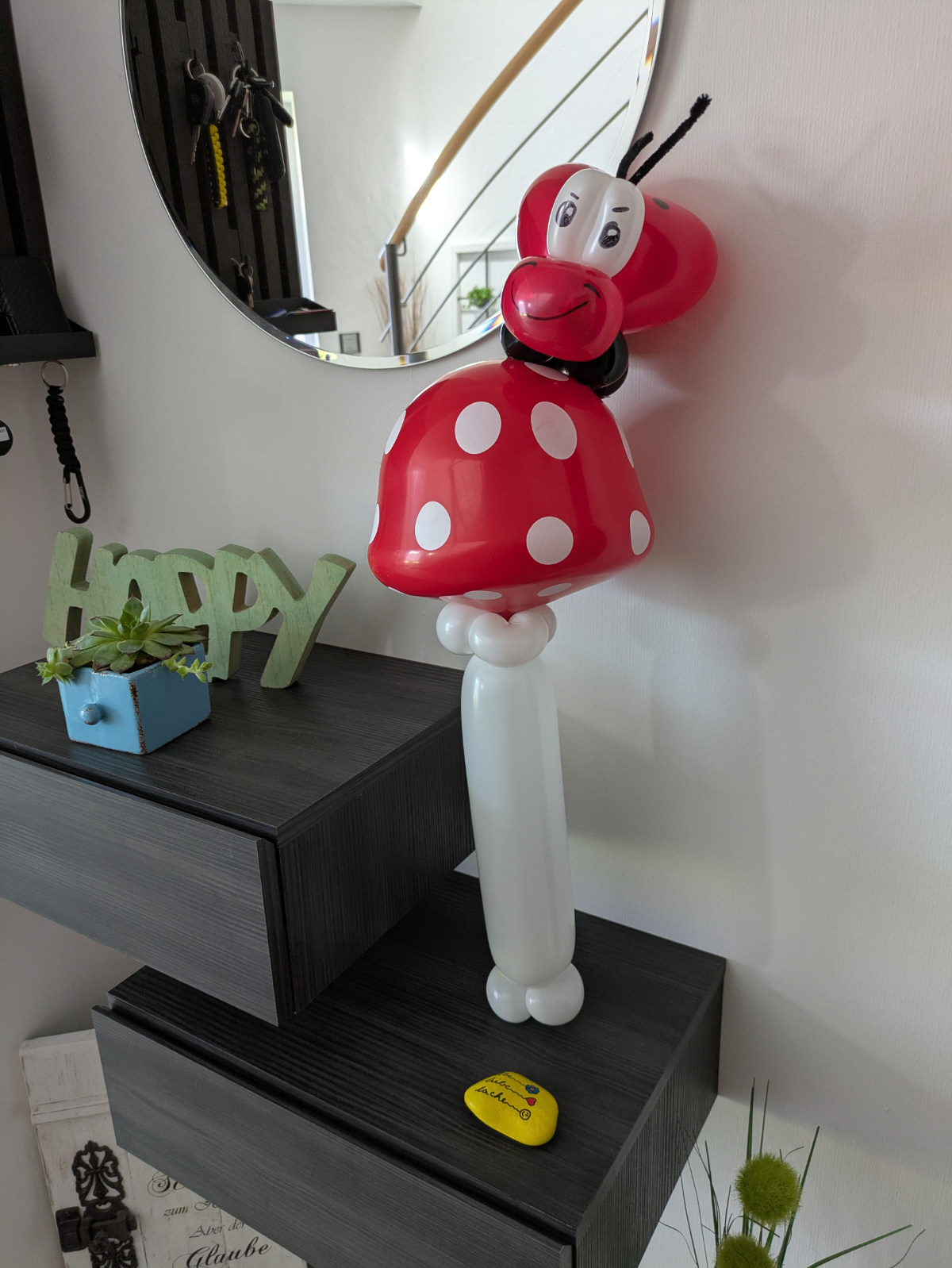 Große Ballonfigur eines Marienkäfers mit rotem Körper und weißen Punkten